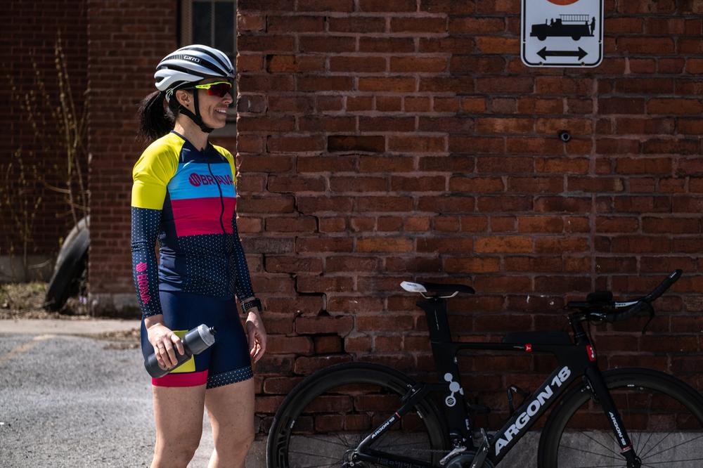 Femme avec vêtements de vélo de route Brava près d'un mur de brique