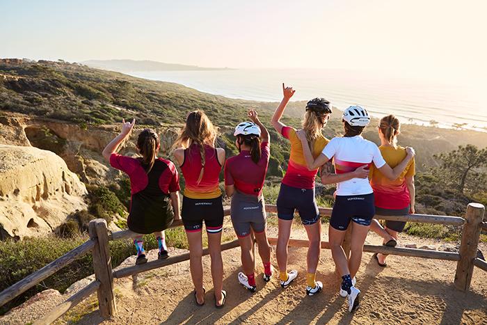 6 femmes de dos sur un observatoire près de la mer habillées en vélo de route Peppermint